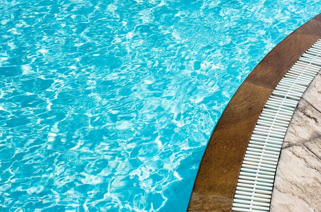 Acqua blu della piscina con riflessi del sole