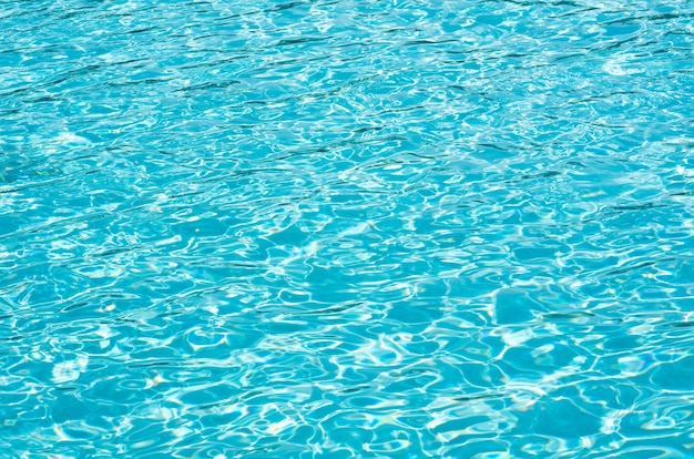 Acqua blu della piscina con riflessi del sole