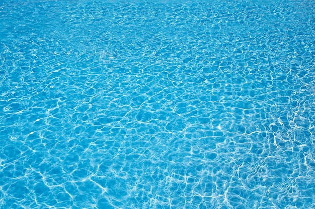 Acqua blu della piscina con riflessi del sole