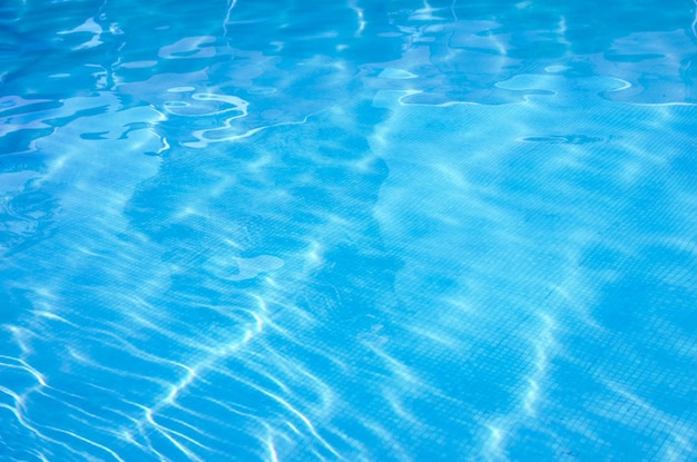 Acqua blu della piscina con riflessi del sole