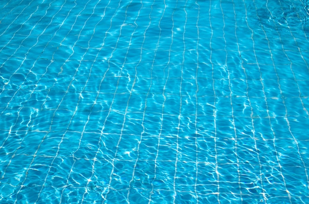 Acqua blu della piscina con riflessi del sole