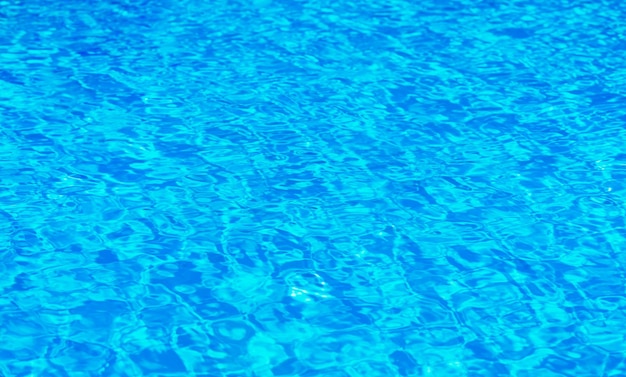 Acqua blu della piscina con riflessi solari