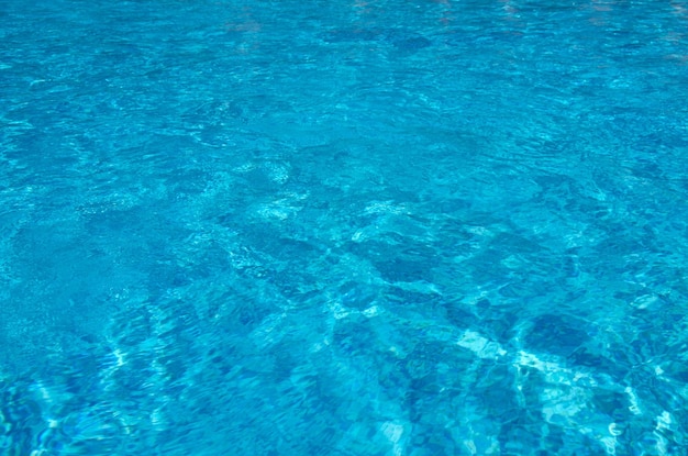 Acqua blu della piscina con riflessi solari