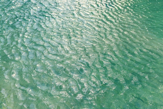 Acqua blu della piscina con un effetto di riflessione delle onde e della luce solare