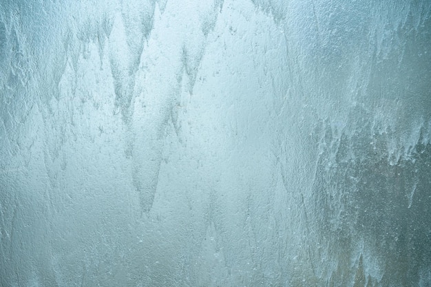 Acqua che cade sulla parete di vetro sfondo sfocato