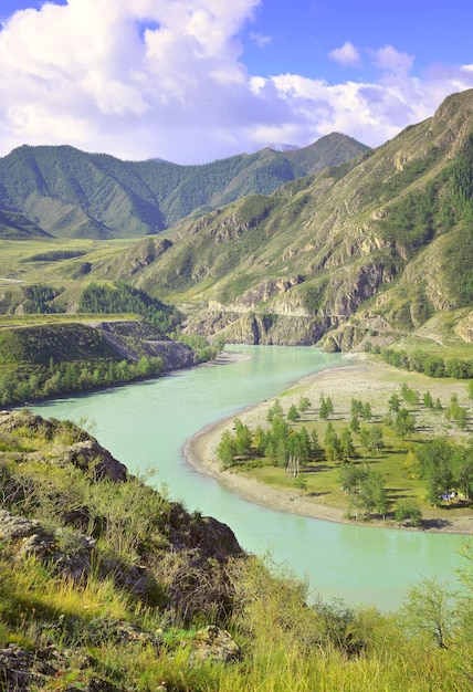 Acqua color smeraldo all'ansa di un fiume di montagna tra le montagne rocciose sotto un cielo blu Siberia