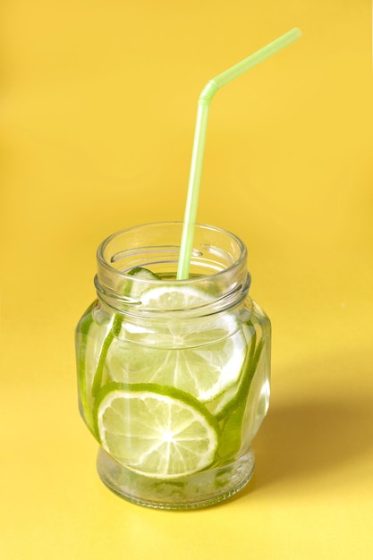 Acqua con spicchi di lime in un barattolo di vetro con ombra