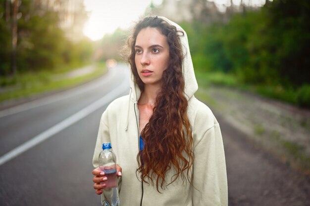 Acqua della bevanda dell'atleta della donna all'aperto