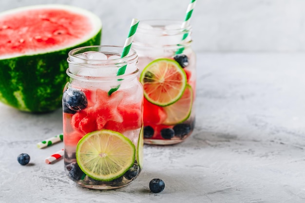 Acqua detox infusa con anguria, lime e mirtillo Cocktail estivo ghiacciato o limonata in barattolo di vetro