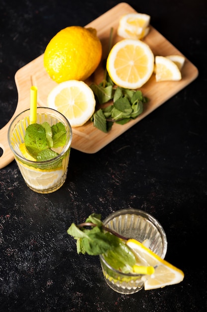 Acqua detox sana e deliziosa con limoni su fondo in legno vintage