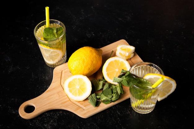 Acqua detox sana e deliziosa con limoni su fondo in legno vintage