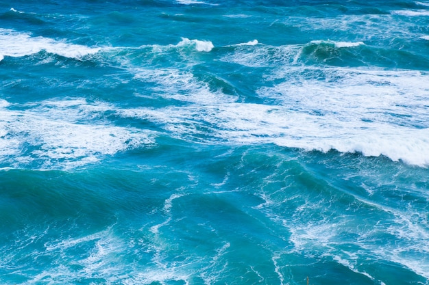 Acqua di mare blu con onde e schiuma bianca