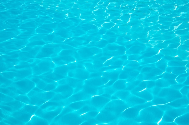 Acqua di piscina azzurra con riflessi solari