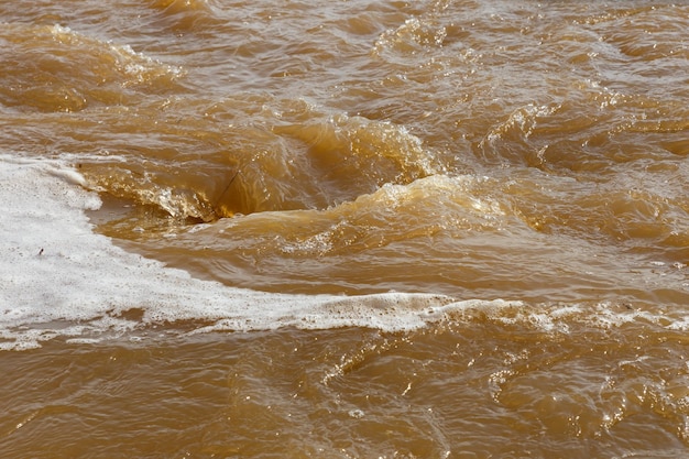 Acqua fangosa del fiume Acqua fangosa sporca con idromassaggio e primo piano di schiuma bianca