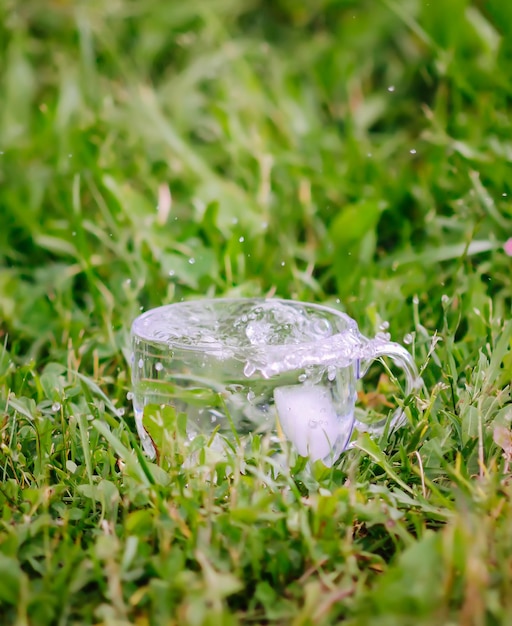 Acqua fresca fresca con cubetti di ghiaccio in una tazza di vetro trasparente all'aperto nelle giornate estive