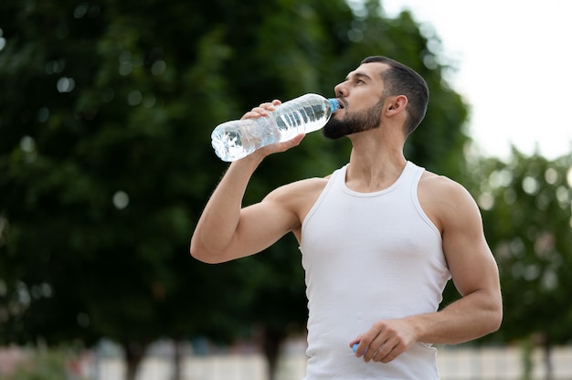 Acqua potabile del giovane sportivo nel parco