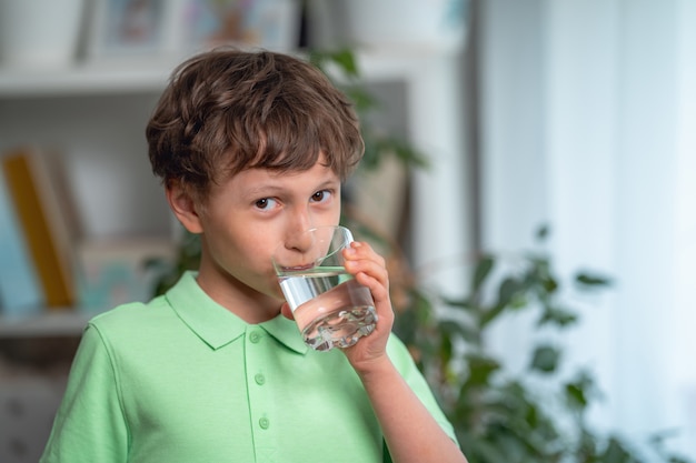 Acqua potabile del ragazzino sveglio a casa Bilancio idrico