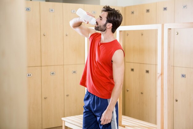 Acqua potabile dell&#39;uomo bello nello spogliatoio