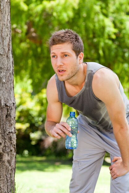 Acqua potabile dell&#39;uomo sportivo nel parco