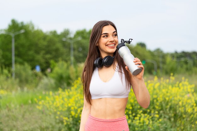 Acqua potabile della bella donna sportiva mentre riposando dall'esercizio.