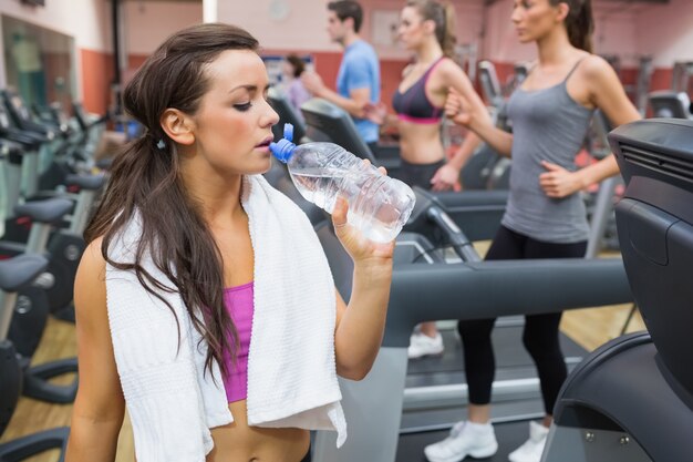 Acqua potabile della donna accanto al tapis roulant