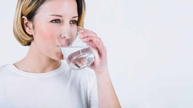 Acqua potabile della donna adorabile su fondo bianco