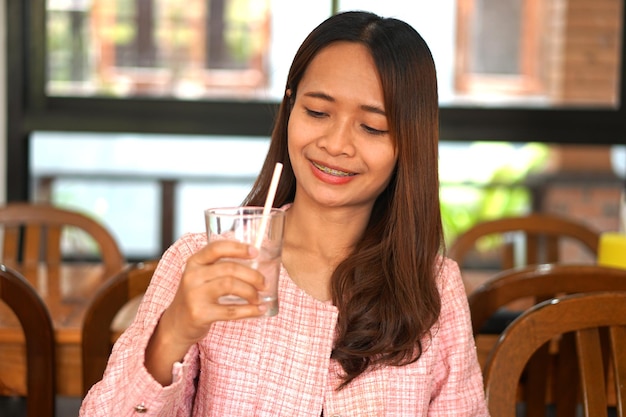 Acqua potabile della donna asiatica in vetro