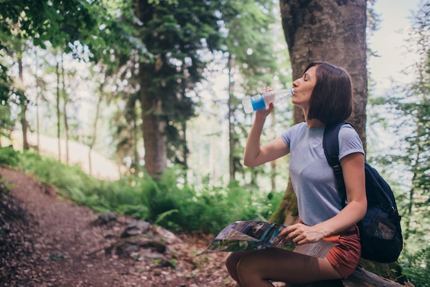 Acqua potabile della donna mentre facendo un'escursione nella foresta