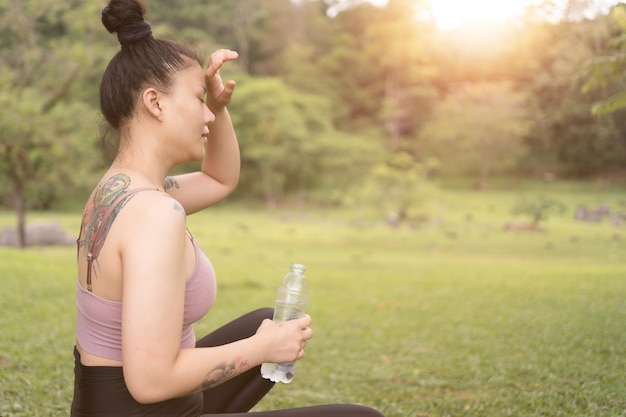 Acqua potabile della giovane bella donna dopo l'esercitazione nel parco