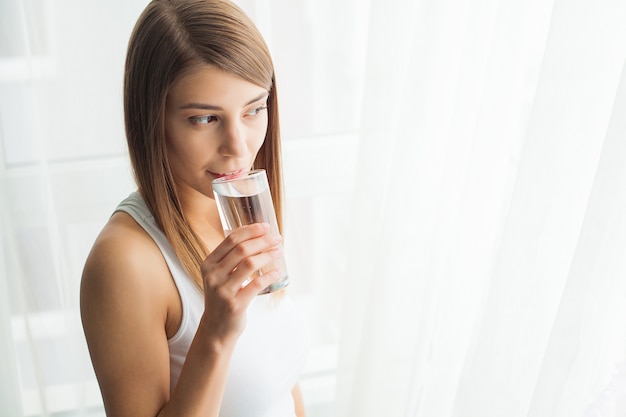 Acqua potabile della giovane donna Bere acqua fresca