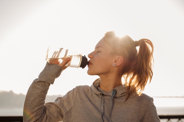 Acqua potabile della giovane donna dopo il riciclaggio