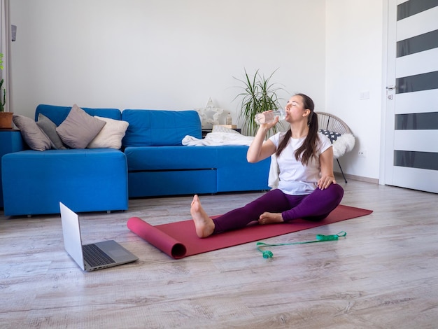 Acqua potabile della ragazza dopo aver praticato lo yoga a casa