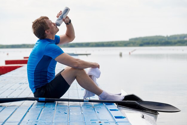 Acqua potabile dello sportivo su un pilastro del lago