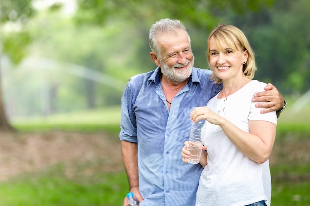 Acqua potabile diritta delle coppie senior del ritratto al parco