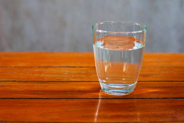 Acqua potabile in un bicchiere su un tavolo di legno