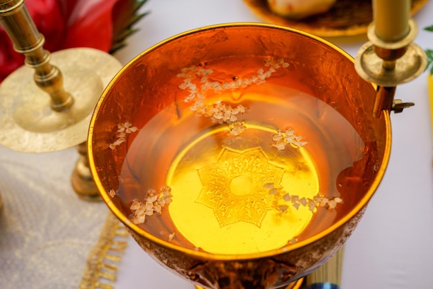 Acqua santa con candela fusa in padella d'oro, cerimonia tradizionale buddista tailandese nel nord della Thailandia.