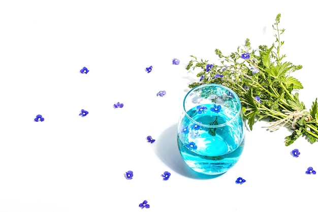 Acqua tonica fredda e blu non ti scordar di me bouquet di fiori su stand alla moda isolato su sfondo bianco