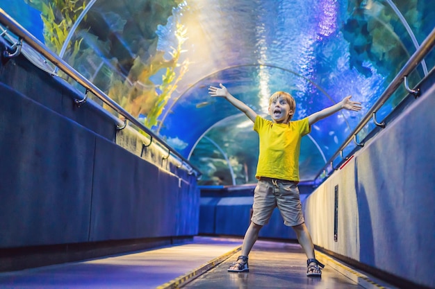 Acquario e visita del ragazzo nel tunnel sottomarino dell'Oceanarium e tartaruga di pesce acquatico di natura subacquea per bambini