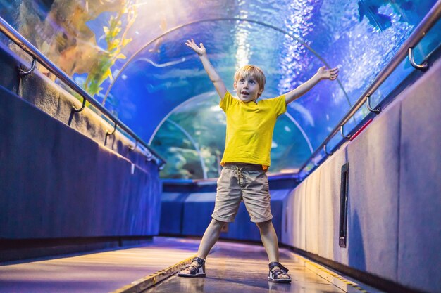 Acquario e visita del ragazzo nel tunnel sottomarino dell'Oceanarium e tartaruga di pesce acquatico di natura subacquea per bambini