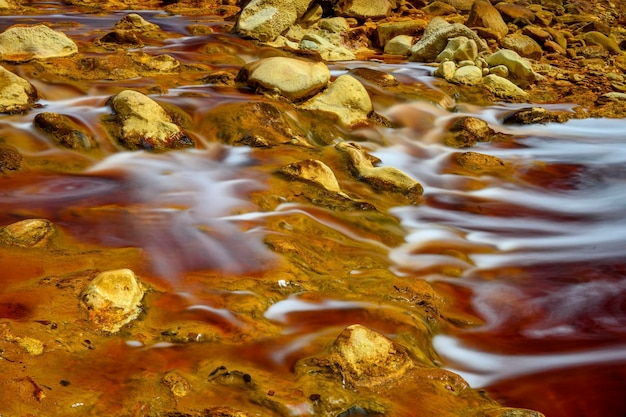 Acque schiumose che scorrono sopra le rocce ricche di minerali di Rio Tintos