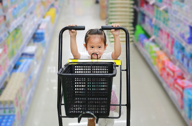 Acquisto della ragazza del piccolo bambino al supermercato