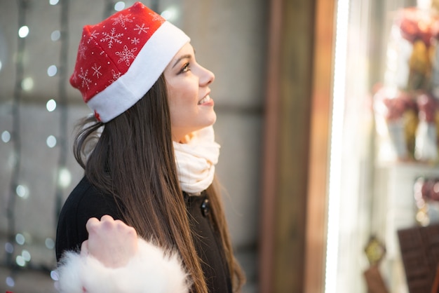 Acquisto sorridente della giovane donna in una città prima del Natale