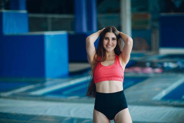 Acrobata della giovane donna che posa in un centro del trampolino