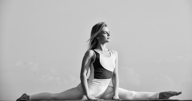 Acrobatica e ginnastica ragazza in split yoga stretching all'aperto pilates studio online Attraente giovane donna sportiva sta lavorando in palestra all'aperto esercizio mattutino ginnasta nazionale ucraino