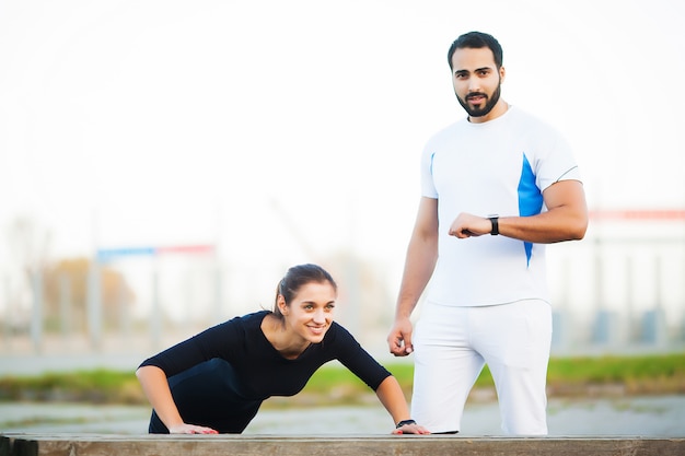 Addestramento della donna con personal trainer al parco