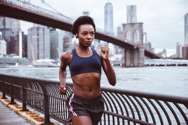 Addestramento della donna dell'atleta di mattina all'alba a New York City