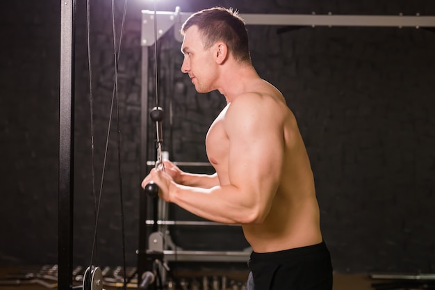 Addestramento muscolare giovane bello in palestra