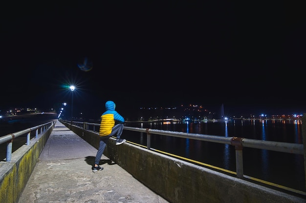 Addestramento notturno su un ponte pedonale di fronte al fiume