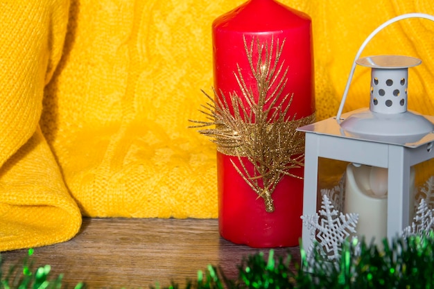 Addobbi e addobbi di Capodanno con un maglione giallo e una candela rossa