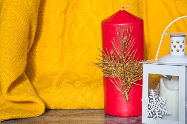 Addobbi e addobbi di Capodanno con un maglione giallo e una candela rossa